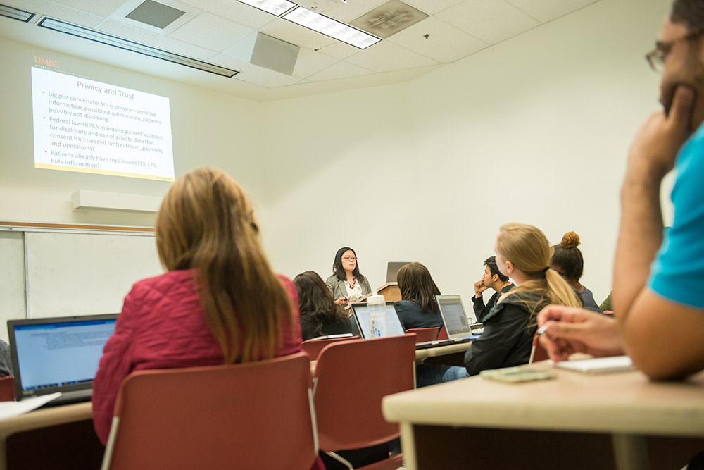 Professor speaking to active students in large classroom